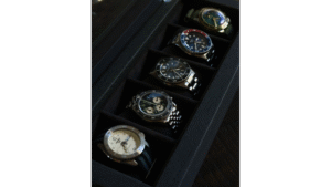 five watches displayed inside of an open watch box